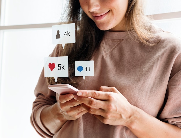 Moça utilizando celular e checando seus números de seguidores e likes no YouTube.
