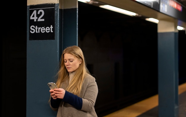 Donna che utilizza smartphone mentre viaggia sulla metropolitana della città