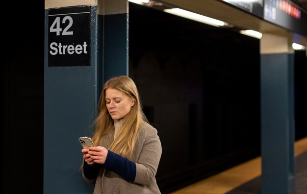 Woman using smartphone while traveling on the city subway