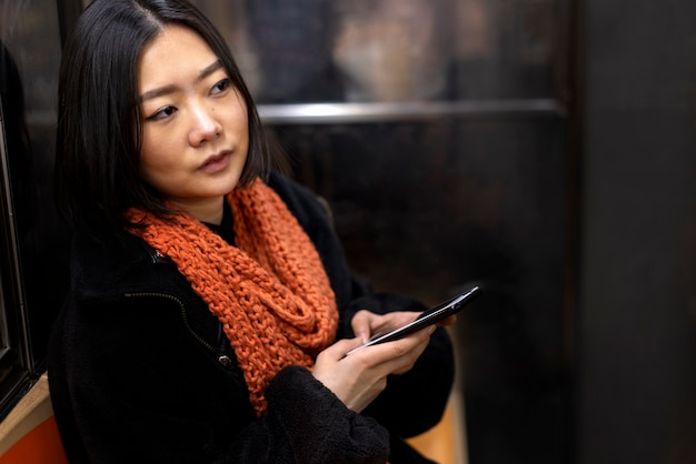 Foto gratuita donna che utilizza smartphone mentre viaggia sulla metropolitana della città