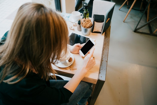 黒い画面でスマートフォンを使用している女性