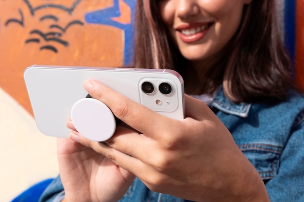 Free photo woman using smartphone with pop socket