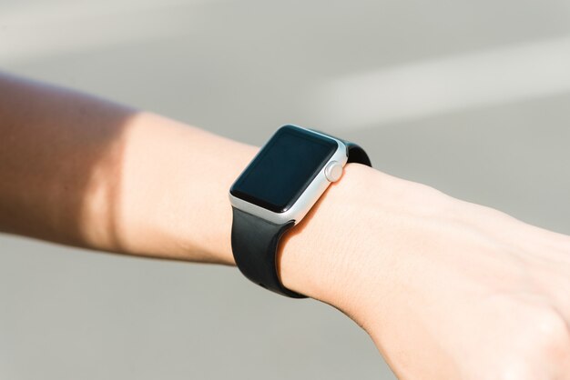 Женщина, использующая smartwatch с уведомлением по электронной почте. устройство smartwatch hand device уведомляет компьютерное интернет-сообщение