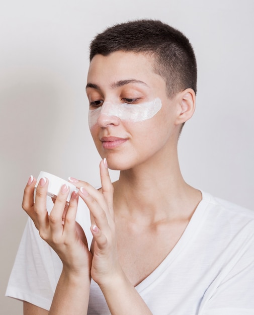 Woman using some face cream for hydrating 