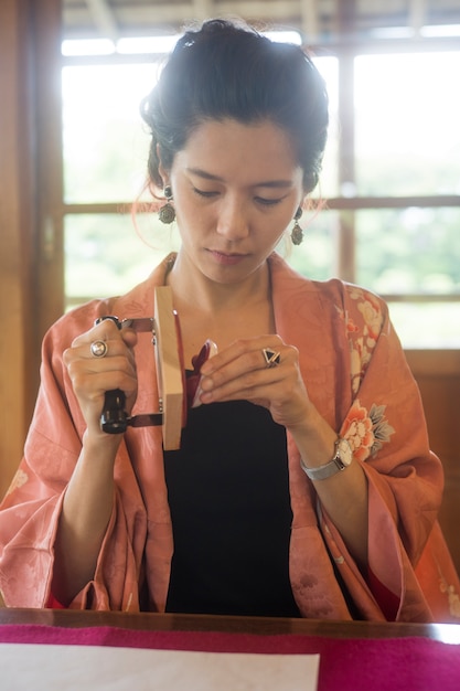 Woman using a stamp on origami paper