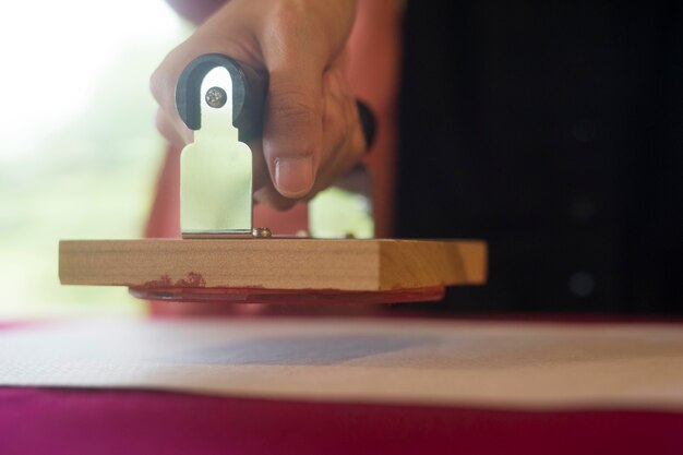 woman using a stamp on origami paper