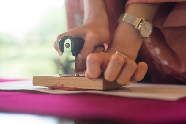 woman using a stamp on origami paper