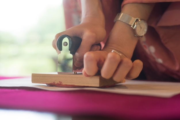 Woman using a stamp on origami paper