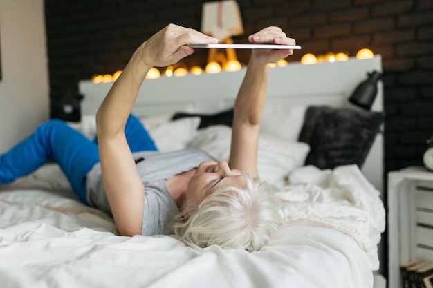 Woman using tablet on bed