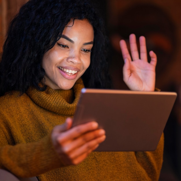 Foto gratuita donna che utilizza un tablet in un bar per una videochiamata