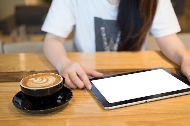 Женщина с помощью планшета в кафе