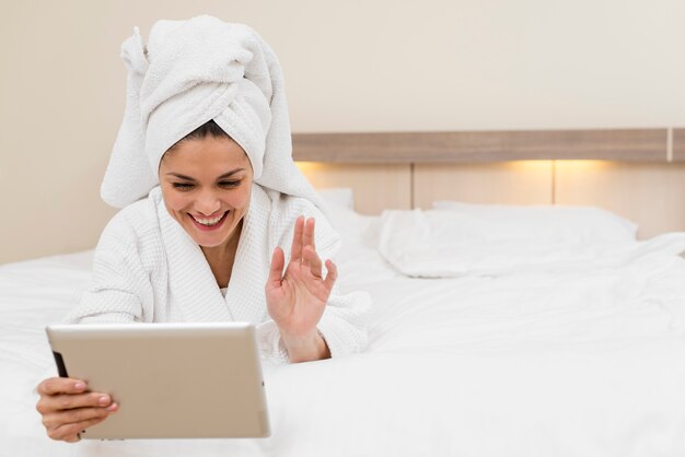 Женщина с помощью планшета в гостиничном номере