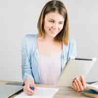 Free photo woman using tablet and making notes