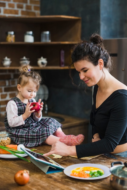 Woman using tablet near daughter