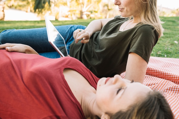 Woman using tablet near friend