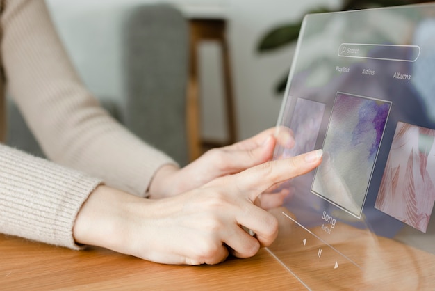 透明なタブレットを使用して音楽の革新的な技術を再生する女性