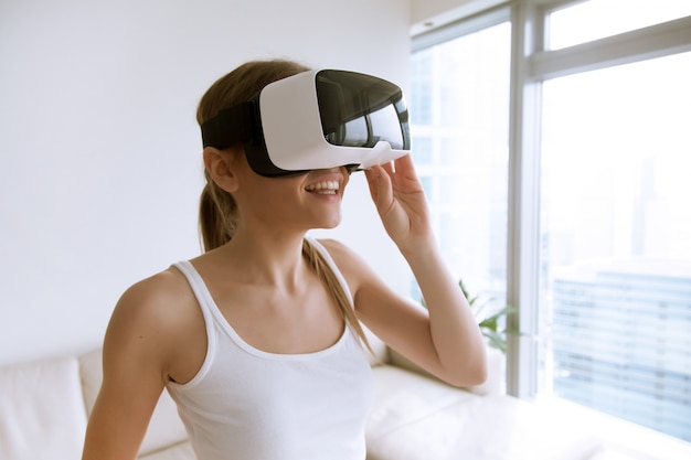 Woman using virtual reality glasses at home