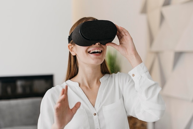 Женщина с помощью гарнитуры виртуальной реальности и улыбается