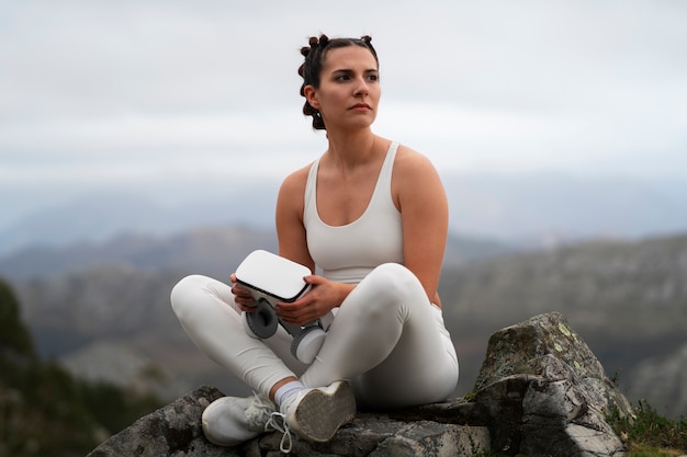 Free photo woman using vr glasses to exercise outdoors in nature