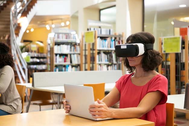 Woman using VR simulator in library