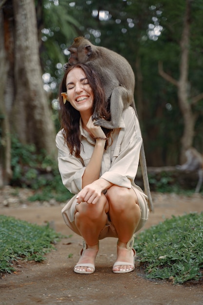 Free photo woman on vacation playing with a monkey