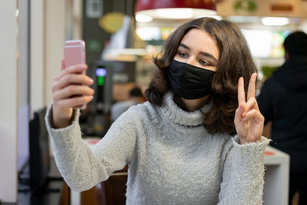 Woman video calling while wearing medical mask