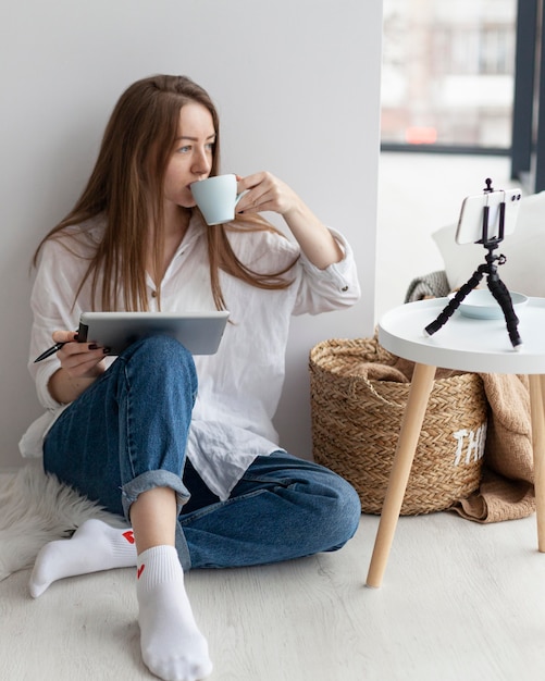 Woman vlogging with her phone indoors