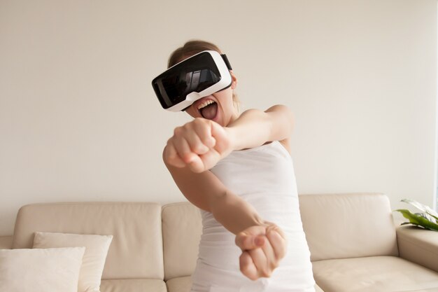 Woman in VR goggles enjoying 3d gaming at home