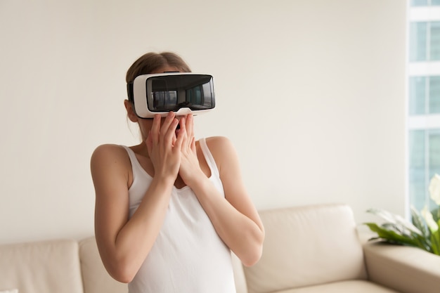 Woman in VR headset frightened because of realistic effects