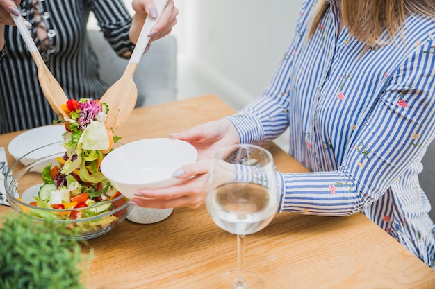 Foto gratuita insalata aspettante della donna alla tavola