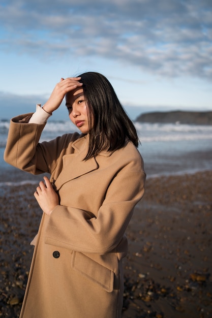 Foto gratuita donna che cammina sulla vista laterale della spiaggia