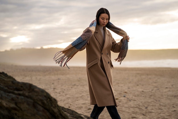 Free photo woman walking on the beach side view