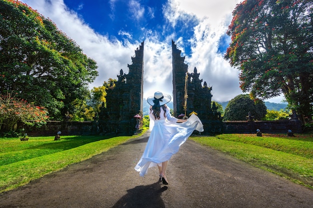 Woman walking at big entrance gate, bali in indonesia