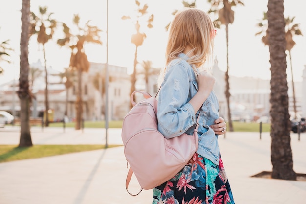 Free photo woman walking in city street in stylish denim oversize jacket, holding pink leather backpack