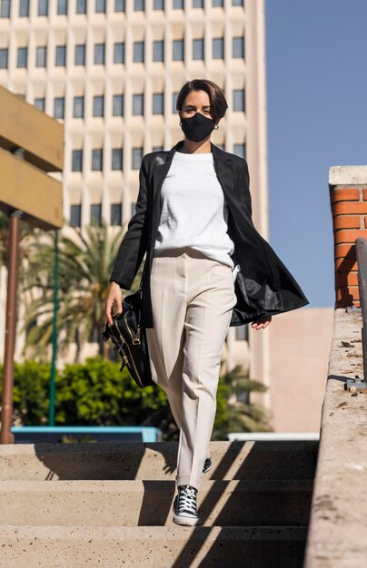 Woman walking in the city while wearing a medical mask