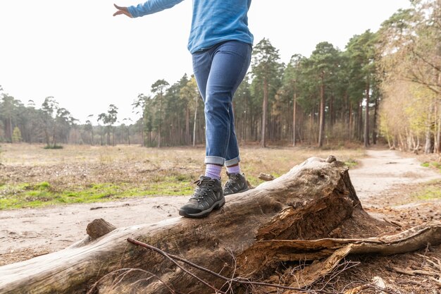 Женщина, идущая на упавшем дереве