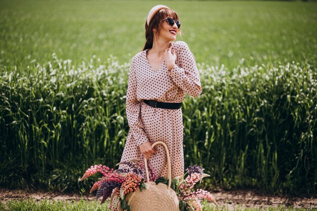 Woman walking in a field with lupinuses