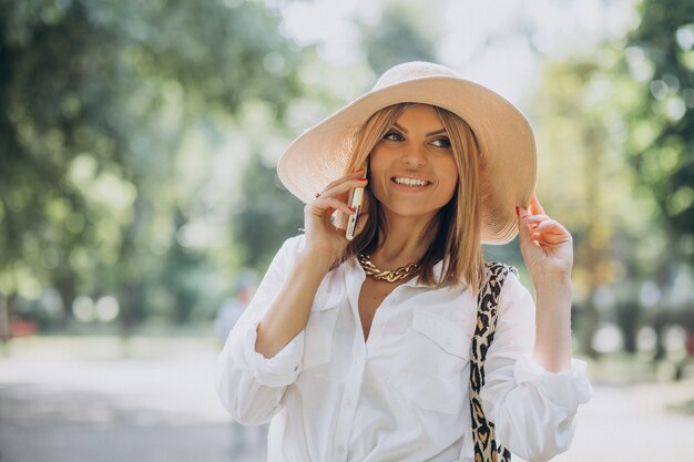 Woman walking in park and talking on the phone