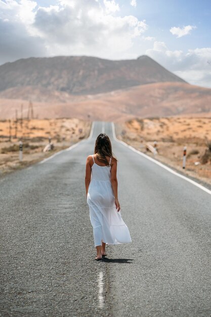 高地の道路を歩く女性