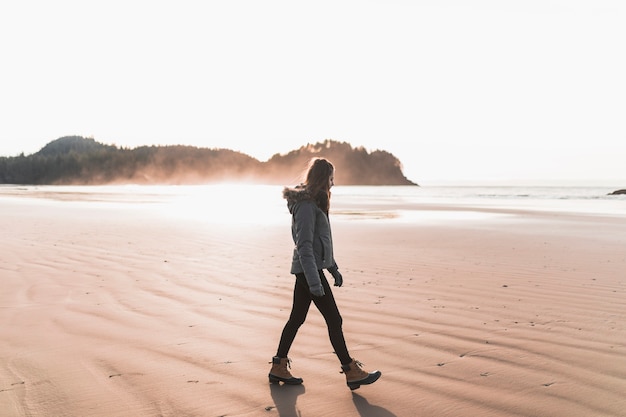 Foto gratuita donna che cammina sulla riva del mare