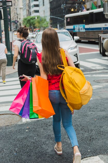 ショッピングカートで通りを歩く女性