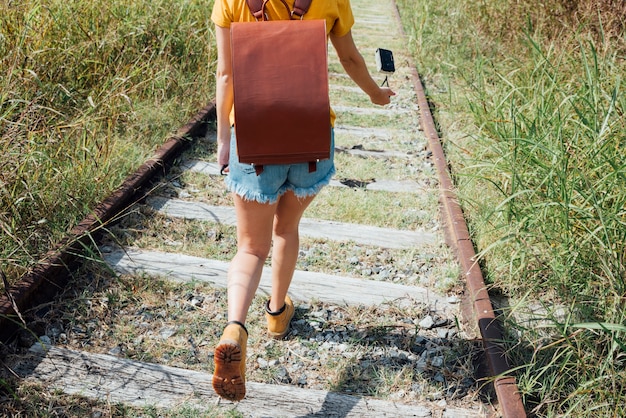 철도 트랙을 통해 걷는 여자