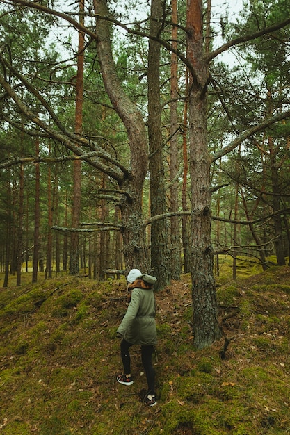 森の木々を歩く女性