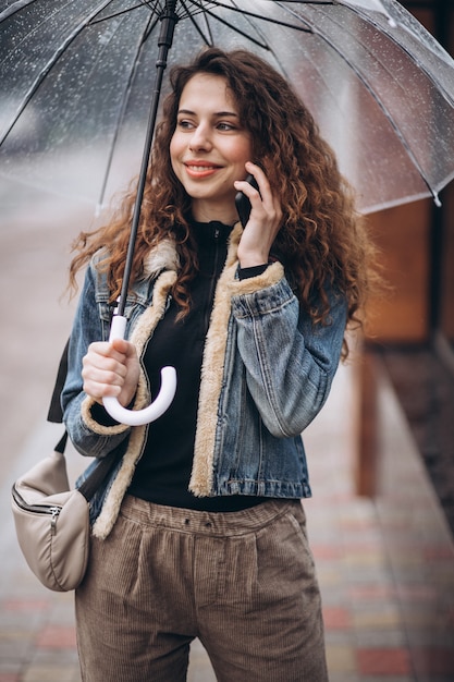 雨の日の傘の下を歩く女性