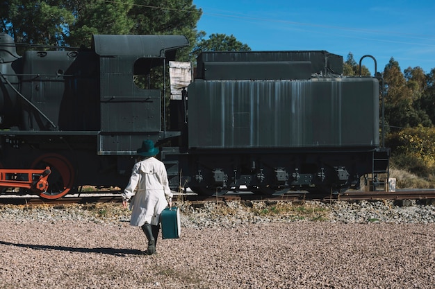 Foto gratuita donna che cammina al treno d'epoca