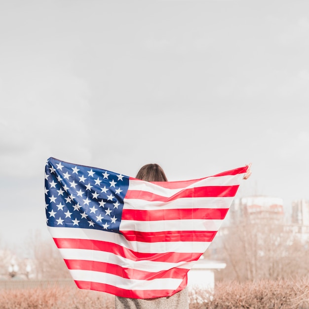 アメリカの国旗と一緒に歩いている女性