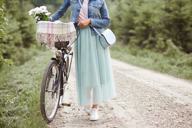 숲에서 자전거와 함께 산책하는 여자