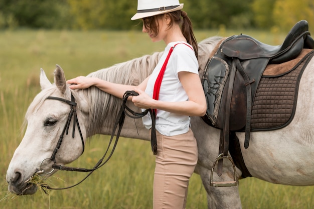 田舎で馬と一緒に歩いている女性