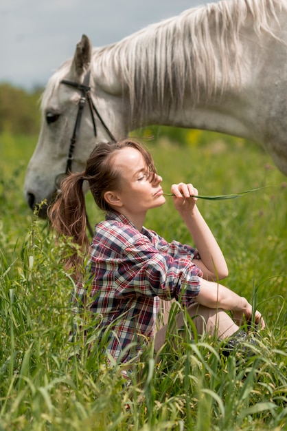 Free photo woman walking with a horse in the countryside