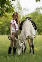 Foto gratuita donna che cammina con un cavallo in campagna
